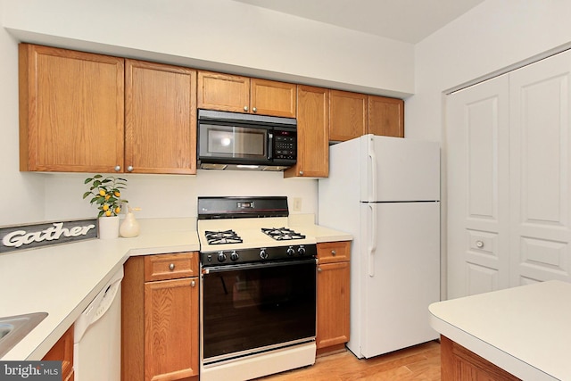 12915 Alton Sq Unit 307, Herndon, VA 20170 - kitchen featuring white appliances, light wood-style floors, light countertops, and brown cabinetry