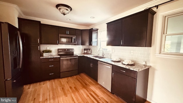 2323 Flag Marsh, Mount Airy, MD 21771 - kitchen with stainless steel appliances, light wood-style floors, dark brown cabinetry, backsplash, and ornamental molding