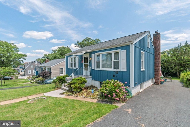 4433 Forest View Ave, Baltimore, MD 21206 - bungalow-style home featuring board and batten siding, a chimney, a front yard, and roof with shingles