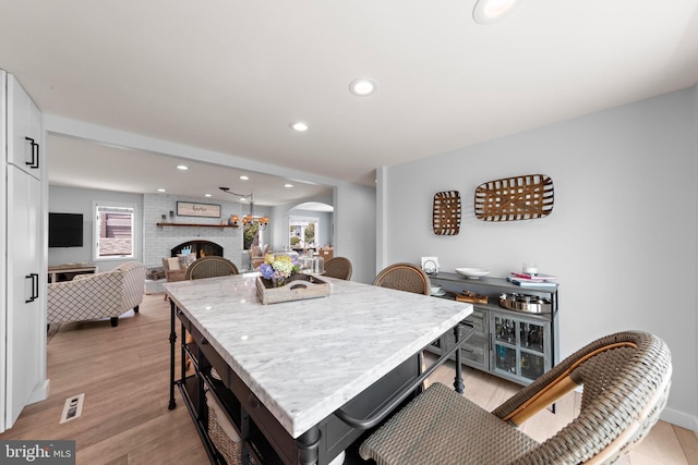 44 Harbor Ln, Long Beach Township, NJ 08008 - dining space featuring arched walkways, light wood finished floors, recessed lighting, and a fireplace