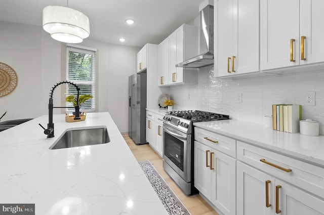 3708 Fairview Ave, Baltimore, MD 21216 - kitchen featuring stainless steel appliances, wall chimney range hood, white cabinetry, decorative backsplash, and light stone countertops
