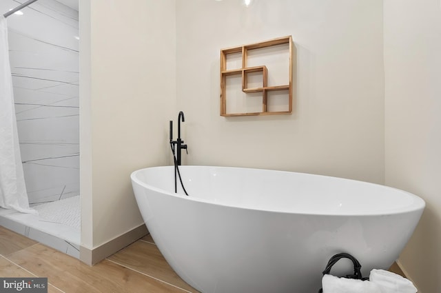 3708 Fairview Ave, Baltimore, MD 21216 - bathroom featuring wood finished floors, a soaking tub, and a stall shower