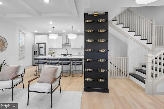 3708 Fairview Ave, Baltimore, MD 21216 - bar area featuring stainless steel fridge, wall chimney range hood, recessed lighting, beam ceiling, and light wood-style flooring