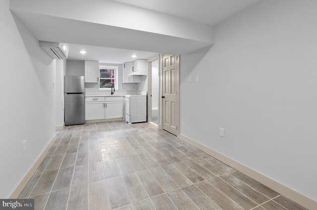3708 Fairview Ave, Baltimore, MD 21216 - kitchen with freestanding refrigerator, range, a wall mounted air conditioner, white cabinetry, and light countertops