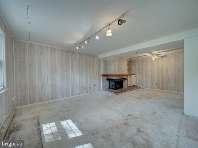 13217 Kephart Ln, Woodbridge, VA 22193 - unfurnished living room featuring rail lighting, wooden walls, a ceiling fan, a fireplace, and carpet