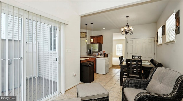 28 Buttonwood Ct, Baltimore, MD 21237 - kitchen featuring stainless steel refrigerator with ice dispenser, a chandelier, light countertops, pendant lighting, and light tile patterned flooring