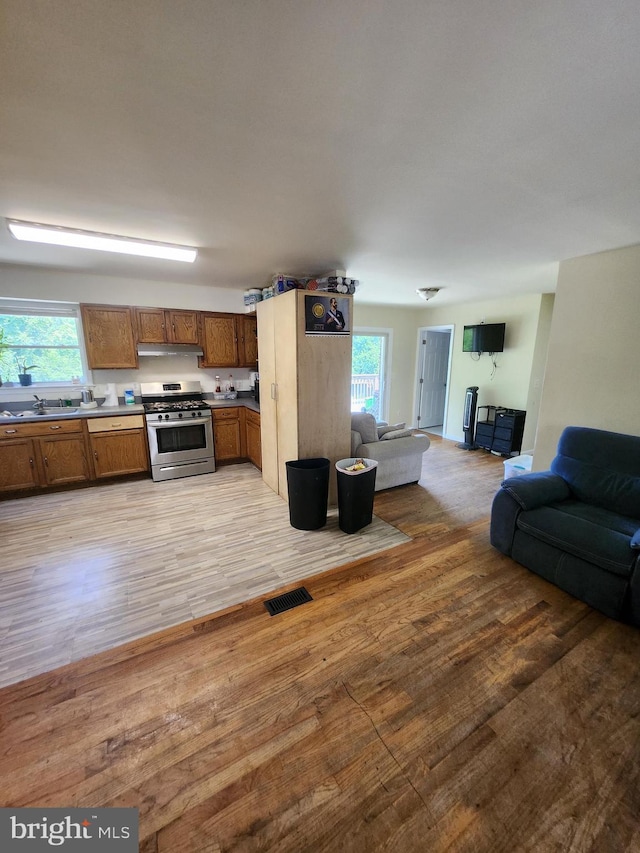 5503 Lanham Station Rd, Lanham, MD 20706 - kitchen featuring stainless steel range with gas stovetop, open floor plan, brown cabinets, and light wood-style floors
