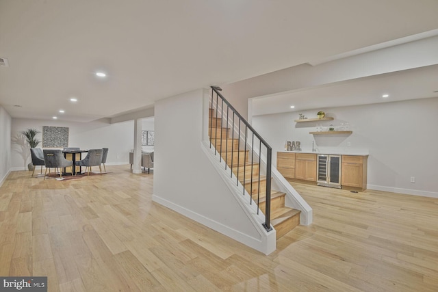 8328 Tuckerman Ln, Potomac, MD 20854 - stairs with wine cooler, bar with sink, wood finished floors, and recessed lighting