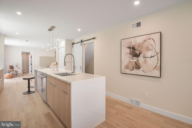 8328 Tuckerman Ln, Potomac, MD 20854 - kitchen featuring modern cabinets, a barn door, light wood-type flooring, stainless steel dishwasher, and recessed lighting