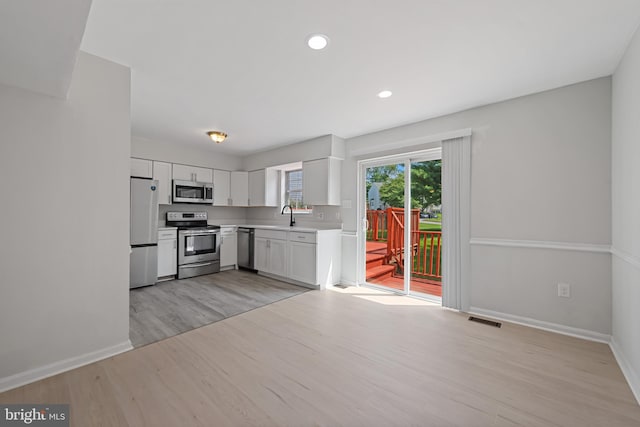 5783 Katsura Ct, Frederick, MD 21703 - kitchen featuring appliances with stainless steel finishes, light wood-type flooring, light countertops, white cabinets, and recessed lighting