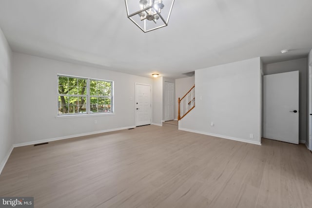 5783 Katsura Ct, Frederick, MD 21703 - unfurnished living room featuring stairs, light wood-type flooring, and a chandelier