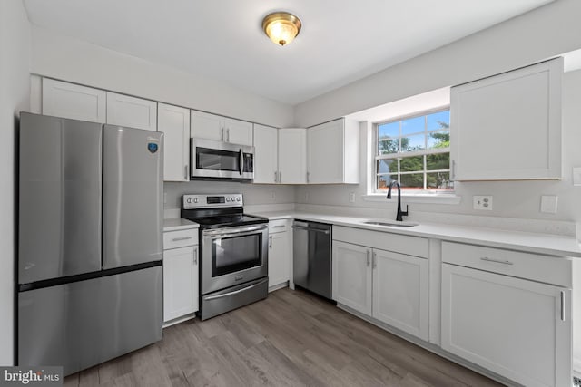 5783 Katsura Ct, Frederick, MD 21703 - kitchen with appliances with stainless steel finishes, white cabinets, light countertops, and light wood-style floors