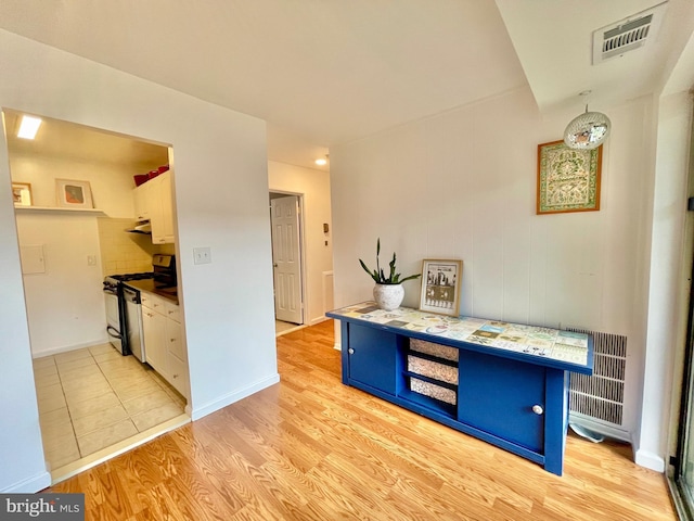 12207 Academy Way Unit 149 7, Rockville, MD 20852 - kitchen with electric stove, blue cabinetry, white cabinetry, light wood-type flooring, and tasteful backsplash