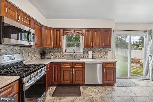 45 Sassafras Dr, Sicklerville, NJ 08081 - kitchen featuring appliances with stainless steel finishes, backsplash, light stone countertops, and brown cabinetry