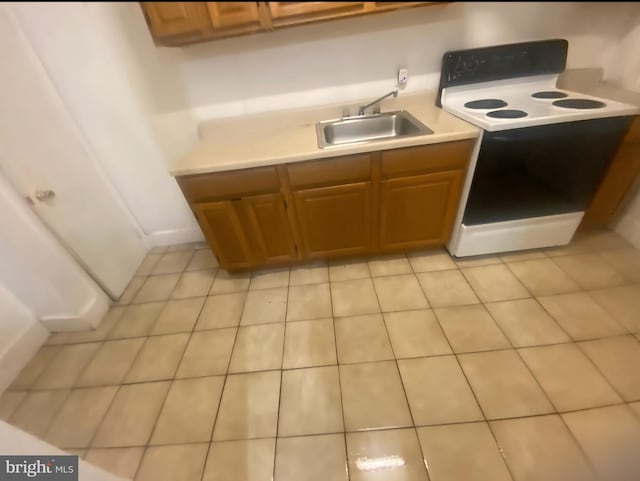 5219 Beaumont Ave, Philadelphia, PA 19143 - kitchen featuring electric stove, light countertops, and brown cabinets