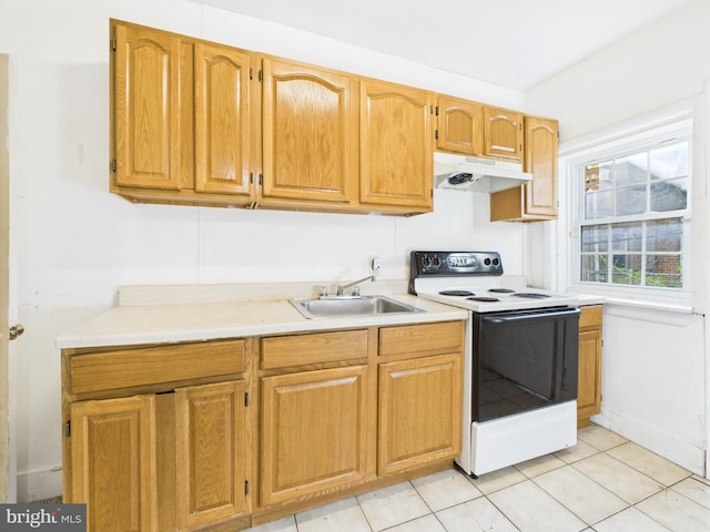 5219 Beaumont Ave, Philadelphia, PA 19143 - kitchen with electric stove, under cabinet range hood, light countertops, and light tile patterned floors
