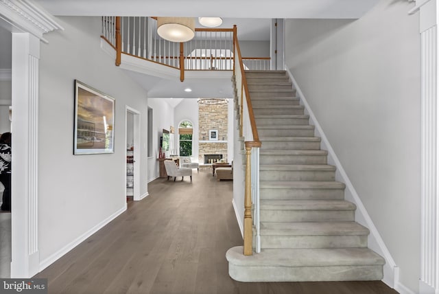 62 Brooks Rd, Moorestown, NJ 08057 - staircase featuring a high ceiling, wood finished floors, and a fireplace