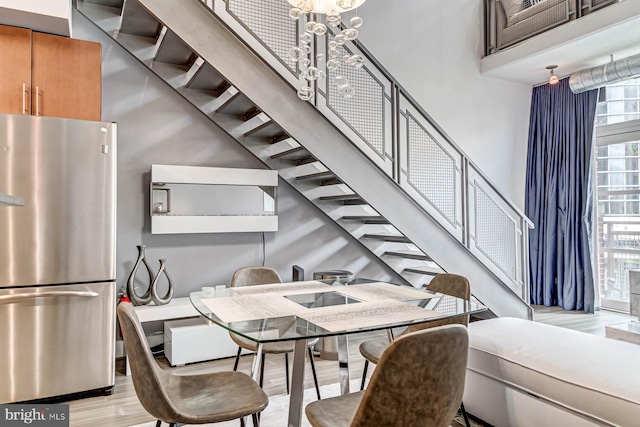 1390 Kenyon St NW Unit 326, Washington, DC 20010 - dining space featuring a high ceiling, light wood-type flooring, stairs, and a chandelier