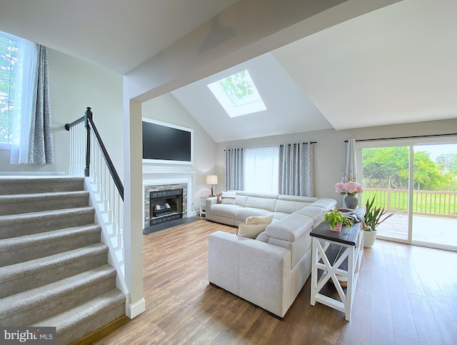107 Heathfield Ct, Middletown, DE 19709 - living area featuring a skylight, lofted ceiling, plenty of natural light, wood finished floors, and a fireplace with raised hearth