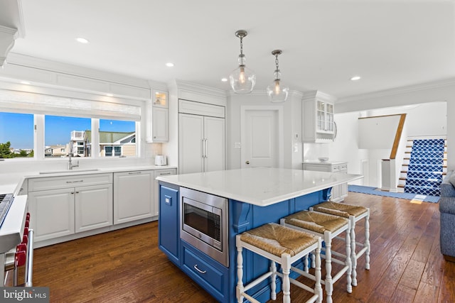 10 11th St, Beach Haven, NJ 08008 - kitchen with stainless steel microwave, blue cabinets, dark wood-type flooring, white cabinets, and glass insert cabinets