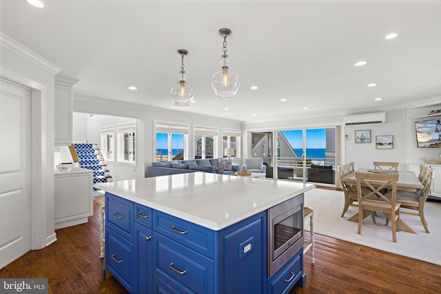 10 11th St, Beach Haven, NJ 08008 - kitchen with a wall mounted air conditioner, stainless steel microwave, blue cabinets, crown molding, and dark wood-style floors