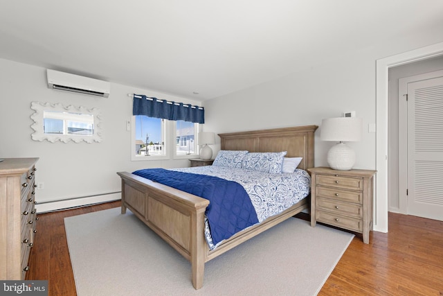 10 11th St, Beach Haven, NJ 08008 - bedroom featuring an AC wall unit, a baseboard radiator, and wood finished floors