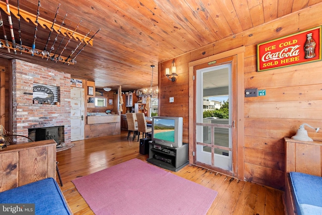 10 11th St, Beach Haven, NJ 08008 - living area featuring a chandelier, hardwood / wood-style flooring, wood ceiling, wood walls, and a fireplace