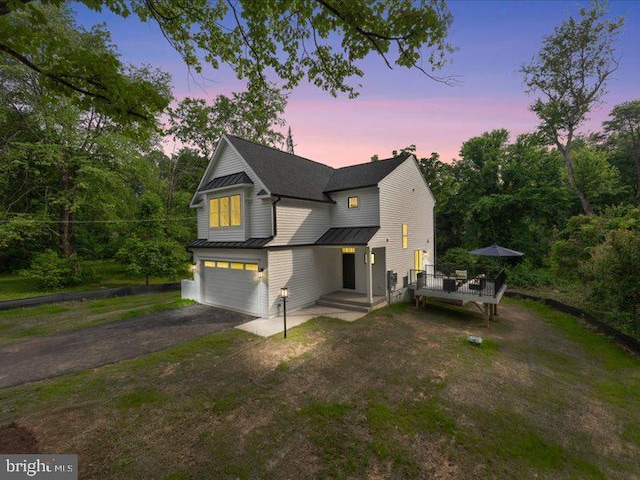 11433 Popes Head Rd, Fairfax, VA 22030 - view of front of house featuring a standing seam roof, an attached garage, driveway, a metal roof, and a wooden deck