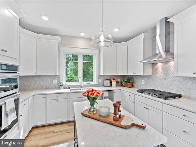 11433 Popes Head Rd, Fairfax, VA 22030 - kitchen with wall chimney range hood, appliances with stainless steel finishes, white cabinetry, tasteful backsplash, and recessed lighting