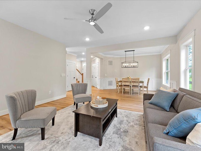 11433 Popes Head Rd, Fairfax, VA 22030 - living area with light wood-style flooring, ornamental molding, ceiling fan, wainscoting, and stairs