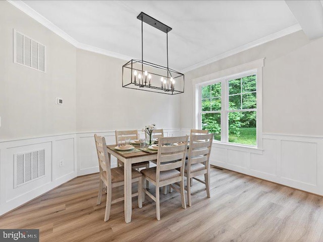 11433 Popes Head Rd, Fairfax, VA 22030 - dining area featuring a chandelier, light wood-style floors, ornamental molding, a decorative wall, and wainscoting