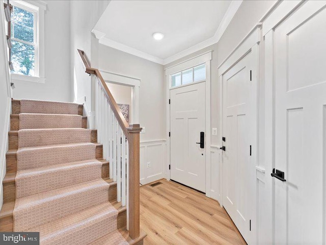 11433 Popes Head Rd, Fairfax, VA 22030 - foyer featuring crown molding, light wood-style flooring, stairs, a wainscoted wall, and a decorative wall