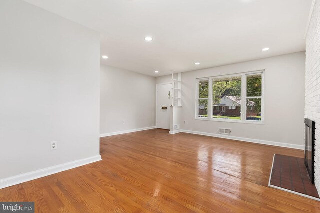 10409 Royalton Ter, Silver Spring, MD 20901 - unfurnished living room with a brick fireplace, wood finished floors, and recessed lighting