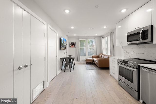 1638 K St NE Unit 101, Washington, DC 20002 - kitchen featuring stainless steel appliances, white cabinetry, light wood-style flooring, recessed lighting, and modern cabinets