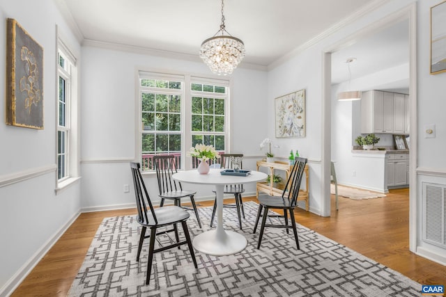 1433 River Oaks Rdg, Charlottesville, VA 22901 - dining room featuring healthy amount of natural light, wood finished floors, a chandelier, and ornamental molding