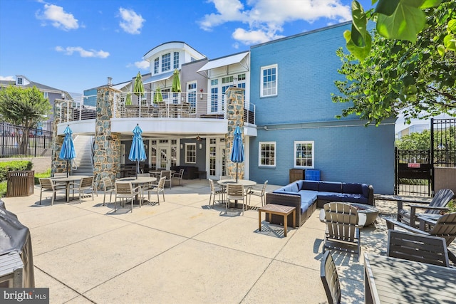 4163 S Four Mile Run Dr Unit 401, Arlington, VA 22204 - back of property featuring a balcony, outdoor lounge area, brick siding, outdoor dining space, and a patio