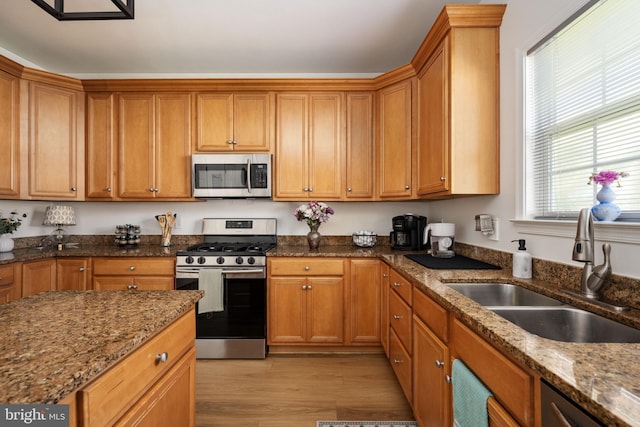 17 Saint Claires Ct, Stafford, VA 22556 - kitchen featuring appliances with stainless steel finishes, light wood-style floors, dark stone countertops, and brown cabinetry