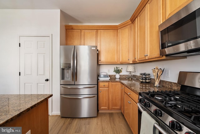 17 Saint Claires Ct, Stafford, VA 22556 - kitchen featuring stainless steel appliances, light wood-style flooring, dark stone countertops, and brown cabinetry