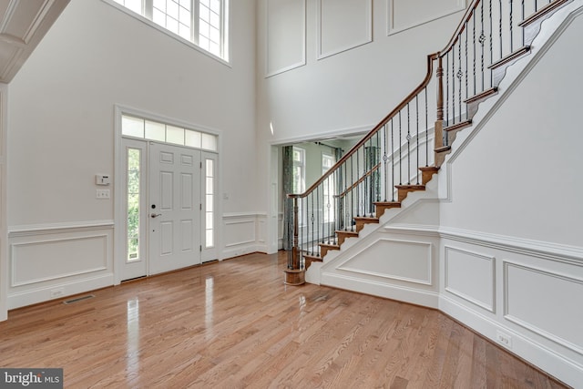 10002 Courthouse Rd, Vienna, VA 22181 - foyer with a decorative wall, healthy amount of natural light, stairway, light wood-type flooring, and a wainscoted wall