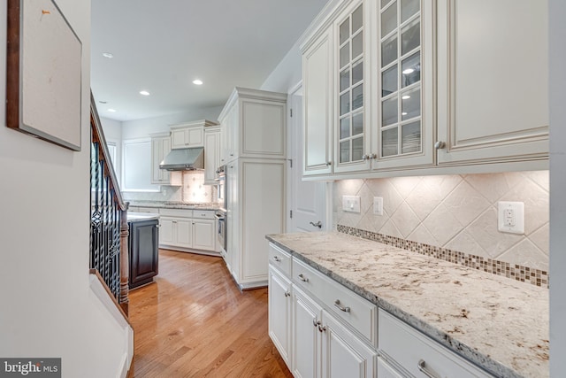 10002 Courthouse Rd, Vienna, VA 22181 - kitchen featuring under cabinet range hood, tasteful backsplash, stainless steel appliances, light wood finished floors, and light stone countertops