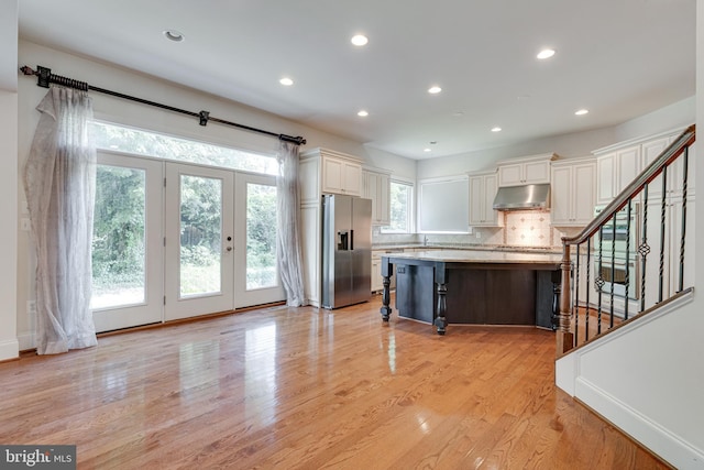 10002 Courthouse Rd, Vienna, VA 22181 - kitchen with stainless steel refrigerator with ice dispenser, under cabinet range hood, tasteful backsplash, a kitchen breakfast bar, and light wood-style flooring