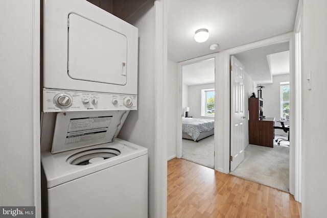 20315 Beaconfield Ter Unit 202, Germantown, MD 20874 - laundry room with stacked washer and clothes dryer and light wood-style flooring