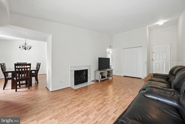 20315 Beaconfield Ter Unit 202, Germantown, MD 20874 - living room featuring a chandelier, light wood-style floors, and a high end fireplace