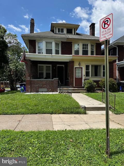 2600 N 5th St, Harrisburg, PA 17110 - american foursquare style home featuring a chimney, a front yard, brick siding, and covered porch