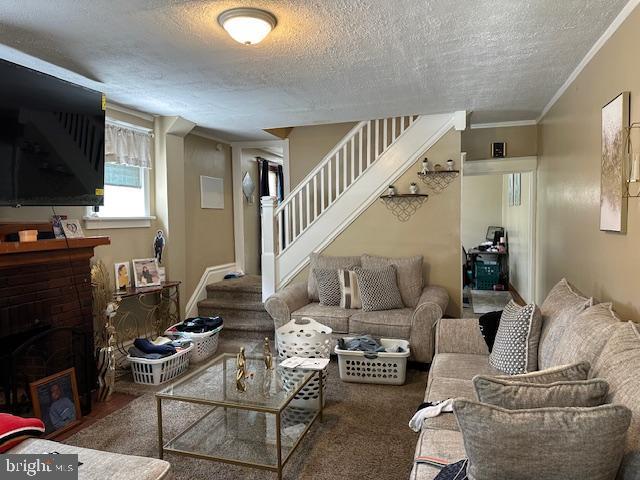 2600 N 5th St, Harrisburg, PA 17110 - living area featuring stairway, a textured ceiling, ornamental molding, and a fireplace with flush hearth