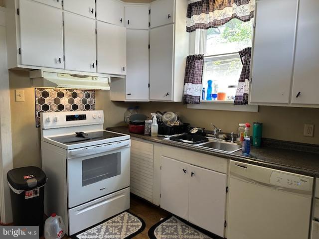 2600 N 5th St, Harrisburg, PA 17110 - kitchen featuring white appliances, under cabinet range hood, dark countertops, and white cabinets
