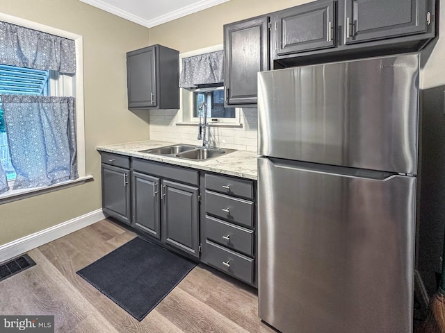171 N York St, Pottstown, PA 19464 - kitchen with freestanding refrigerator, ornamental molding, light wood-style flooring, tasteful backsplash, and gray cabinets