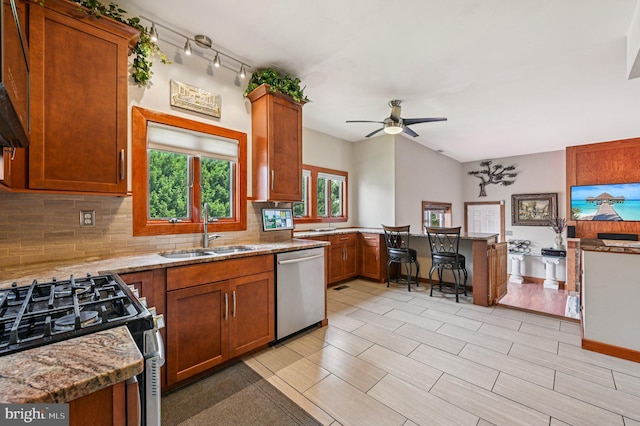 1802 Disney Estates Cir, Severn, MD 21144 - kitchen with appliances with stainless steel finishes, tasteful backsplash, a ceiling fan, a peninsula, and brown cabinets