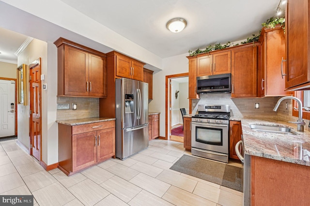 1802 Disney Estates Cir, Severn, MD 21144 - kitchen with appliances with stainless steel finishes, ornamental molding, decorative backsplash, light stone countertops, and brown cabinets