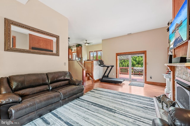 1802 Disney Estates Cir, Severn, MD 21144 - living room featuring wood finished floors, a stone fireplace, a ceiling fan, and stairs
